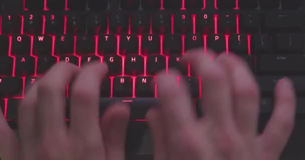 Hands typing in the dark on illuminated keyboard — Stock Video