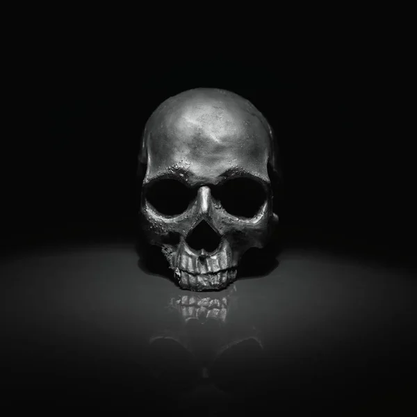 Spooky dark black skull aginast dark background — Stock Photo, Image