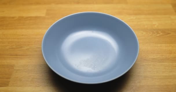 Clean bowl without food dropping spoon into it in slow motion from 120fps — Stock Video