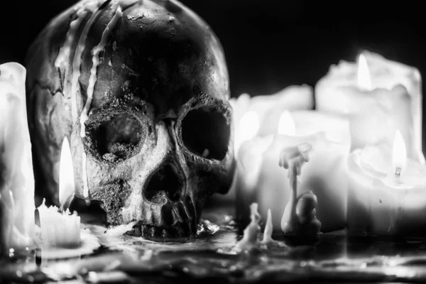 Candles and human skull in darkness closeup in black and whiter — Stock Photo, Image