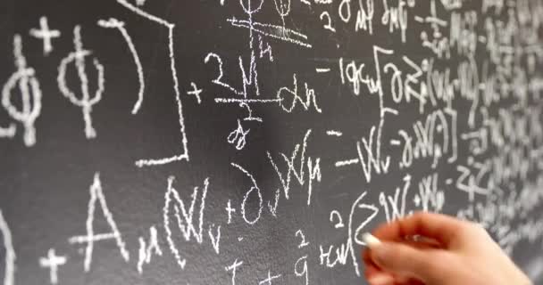 Writing mathematical formulas on dark black chalk board — Stock Video