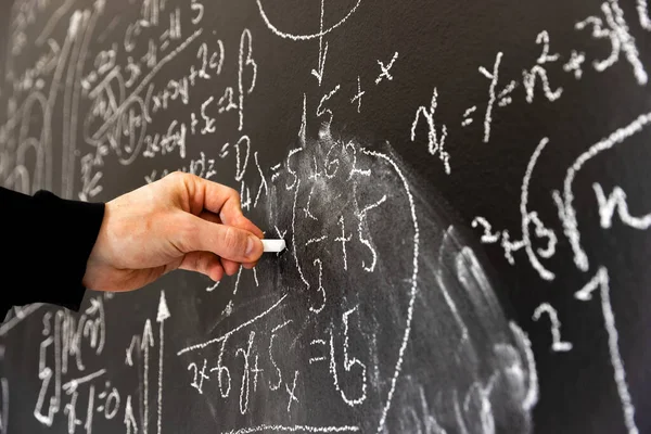 Mathematical formulas on dark black chalk board Stock Picture