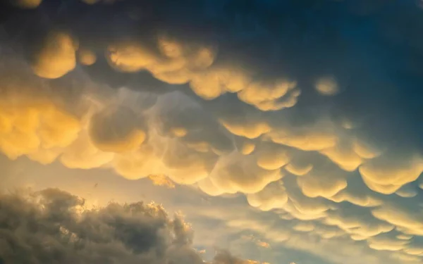 Dramatic sunset sky background with mammatus clouds — Stock Photo, Image
