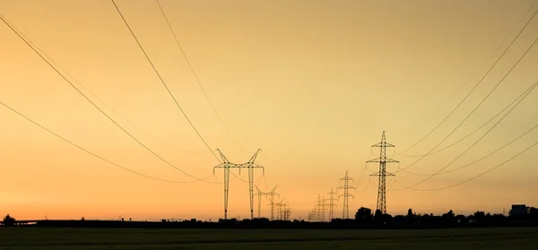 Grandes torres de transmisión al atardecer — Foto de Stock