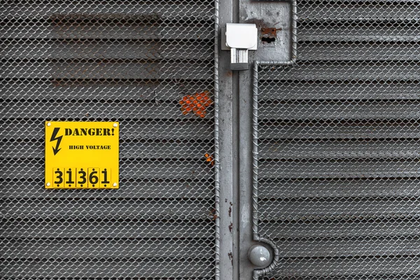 Sarı uyarı işareti ile gri çit — Stok fotoğraf