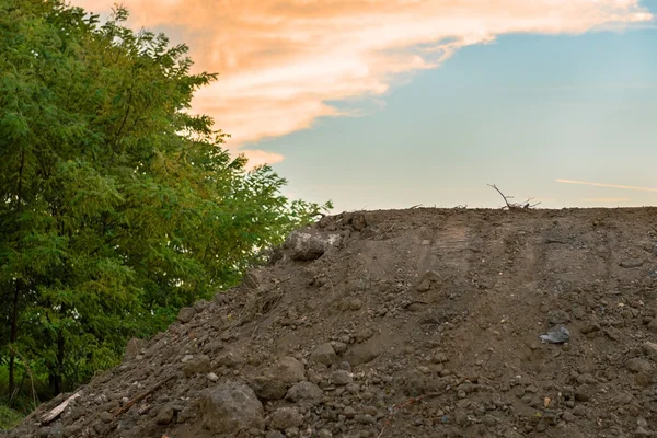 Large pile of soil under blue sky — Stock Photo, Image