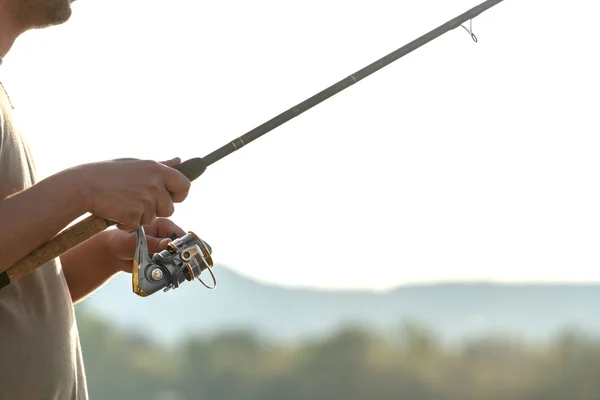 Modern clean fishing rod in hands — Stock Photo, Image