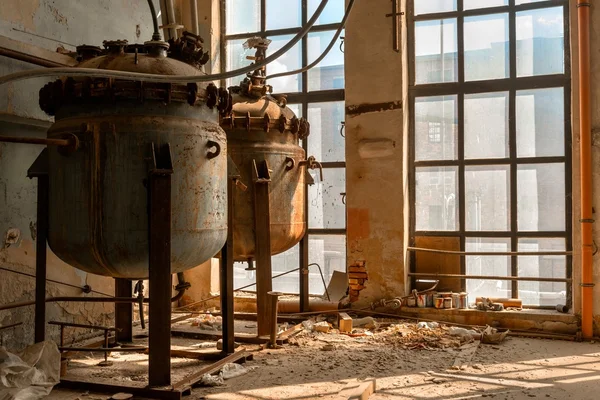 Industrial containers in abandoned interior — Stock Photo, Image