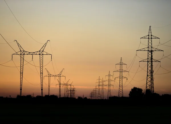 Grandes torres de transmisión al atardecer — Foto de Stock