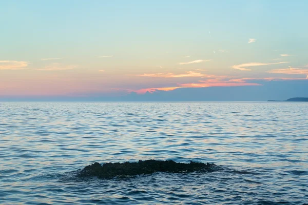 Spiaggia con rocce e cielo nuvoloso — Foto Stock