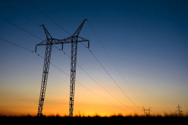 Büyük enerji nakil direkleri mavi saatte — Stok fotoğraf