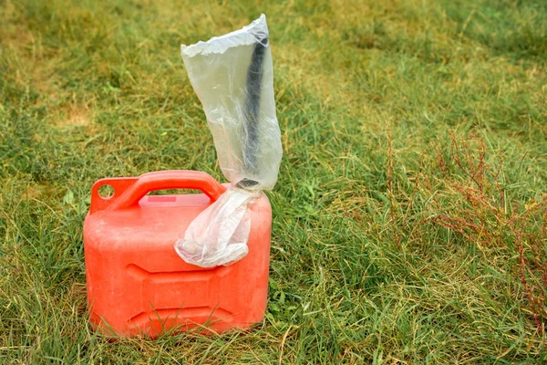 Röda jerrycan på grönt gräs — Stockfoto