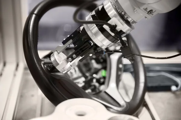 Robotic arm tearing down steering wheel — Stock Photo, Image