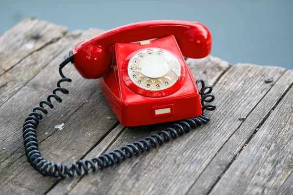 Teléfono rojo en la cubierta de madera —  Fotos de Stock