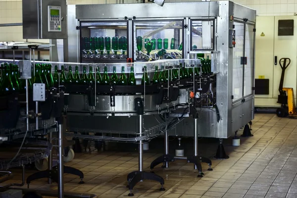 Muchas botellas en la cinta transportadora —  Fotos de Stock