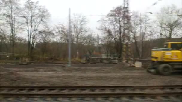 Movimiento horizontal desde la ventana del tren con excavadoras en la zona de construcción — Vídeo de stock