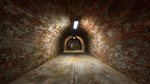 Lange ondergrondse baksteen tunnel hoek geschoten — Stockfoto