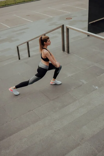 Een jong blank meisje, traint op straat, in sportkleding, in de stad — Stockfoto