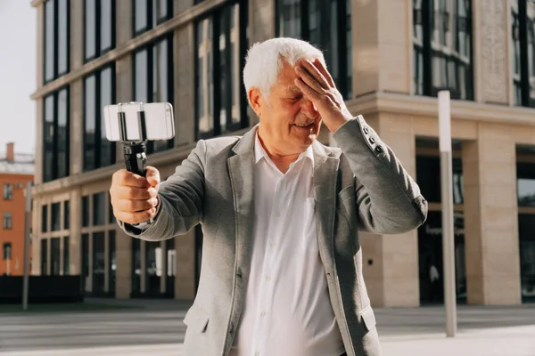 Avô aposentado elegante, faz selfie com um smartphone no parque. — Fotografia de Stock