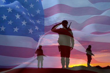 Gün batımına karşı Amerikan bayrağı taşıyan bir askerin siluetleri. Anma Günü, Gaziler Günü