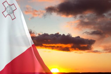 Gün batımına karşı Malta bayrağı. Ulusal Tatil Konsepti
