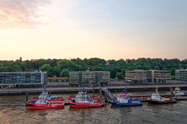 Hafencity, Hamburg, Almanya 'daki Elbe Nehri' nde gün batımında römorkör. 5 Temmuz 2012.