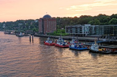 Hafencity, Hamburg, Almanya 'daki Elbe Nehri' nde gün batımında römorkör. 5 Temmuz 2012.
