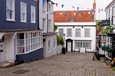 Lymington Hampshire - İngiltere 'de Quay Hill caddesi boyunca tepe boyunca uzanan vitrinlerde rengarenk duvarlar ve koyu pencereler - 20 Mayıs 2021