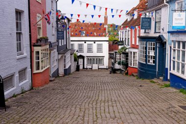 Lymington Hampshire - İngiltere 'de Quay Hill caddesi boyunca tepe boyunca uzanan vitrinlerde rengarenk duvarlar ve koyu pencereler - 20 Mayıs 2021