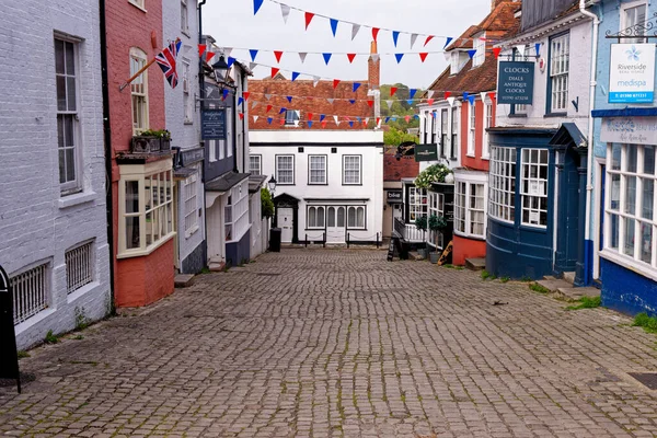 Lymington Hampshire - İngiltere 'de Quay Hill caddesi boyunca tepe boyunca uzanan vitrinlerde rengarenk duvarlar ve koyu pencereler - 20 Mayıs 2021