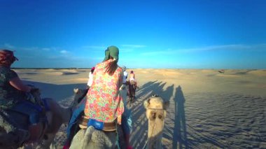 Sahra, Tunus - 7 Ekim 2024 Çölde develi kervan. Tunus 'ta turistik yerler. Develerle çöle yolculuk..