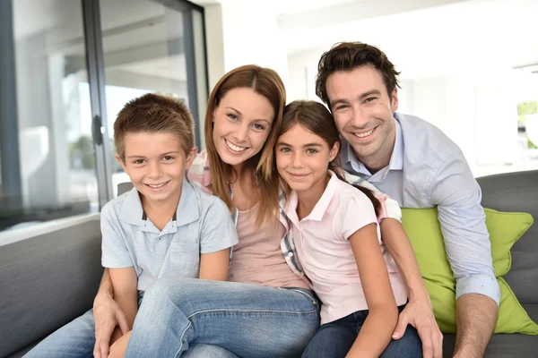 Famille assise sur canapé à la maison — Photo