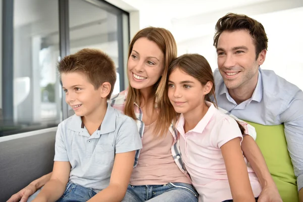 Family sitting on sofa at home — Stock Photo, Image