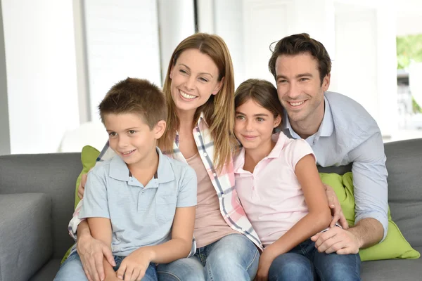 Happy family sitting on sofa — Stock Photo, Image