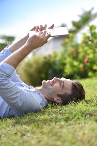 Man leest boek over digitale tablet — Stockfoto