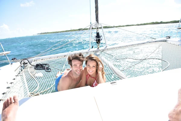 Pareja relajándose en la red de catamarán — Foto de Stock