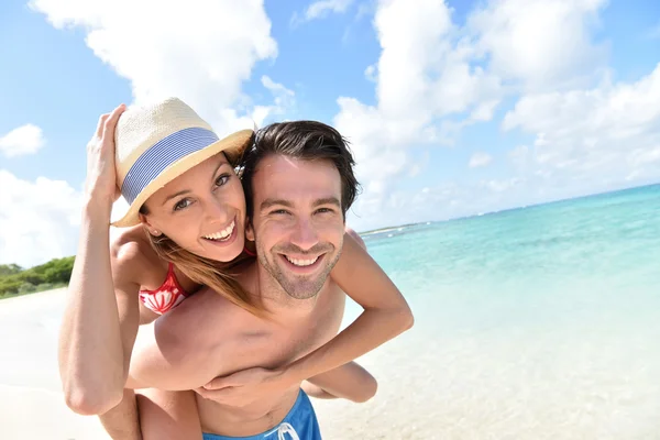 Man giving piggyback ride to girlfriend — Stock Photo, Image