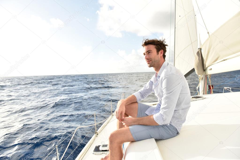 Handsome man relaxing on saiboat