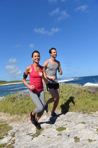 Jogger laufen am Meer entlang — Stockfoto