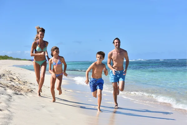 Family running on a sandy beach — Stock Photo, Image