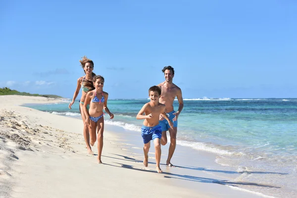 Kumlu bir plaj üzerinde çalışan aile — Stok fotoğraf