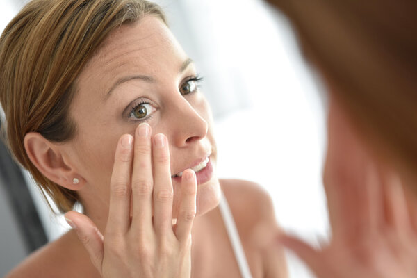 Woman applying facial cream