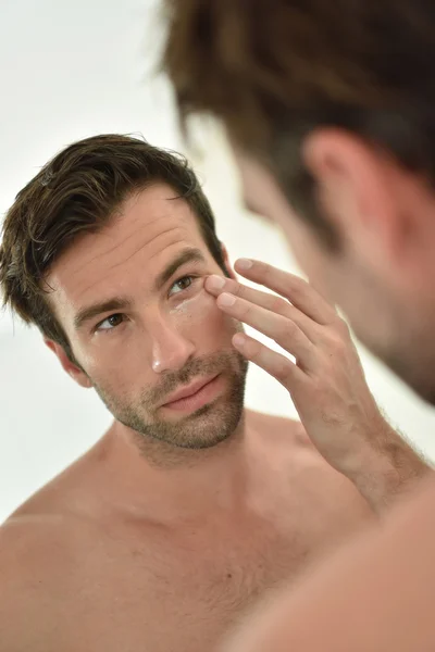 Homem aplicando creme facial — Fotografia de Stock