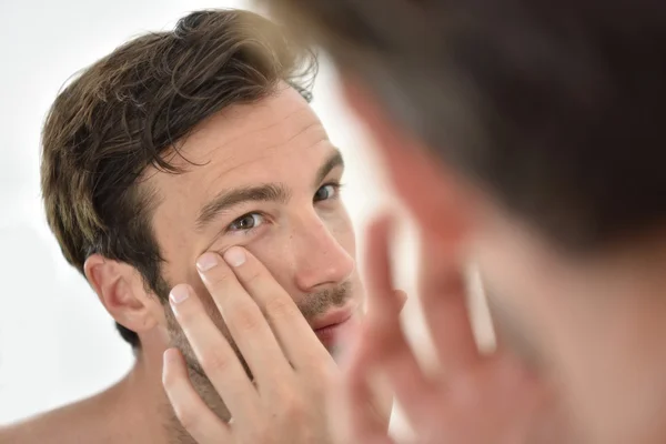 Man tillämpar ansiktskräm — Stockfoto