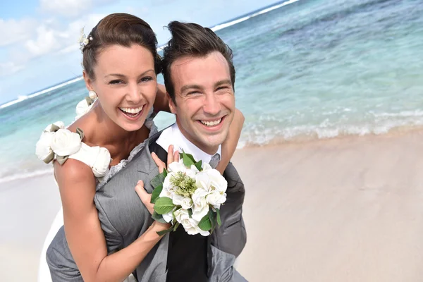 Groom giving piggyback ride — Stock Photo, Image