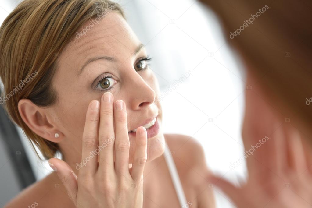 Woman applying facial cream