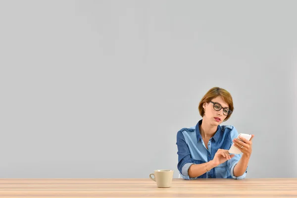 Mujer sentada en el escritorio enviando mensaje —  Fotos de Stock