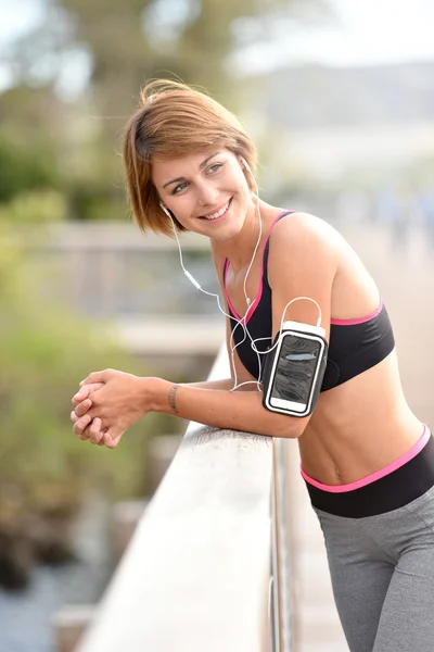 Woman in running outfit listening to music — Stock Photo, Image