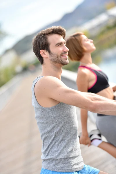 Couple stretching out after running — Stock Photo, Image