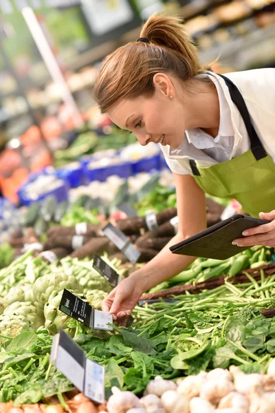 Υπάλληλος σούπερ μάρκετ βάζοντας λαχανικά — Φωτογραφία Αρχείου